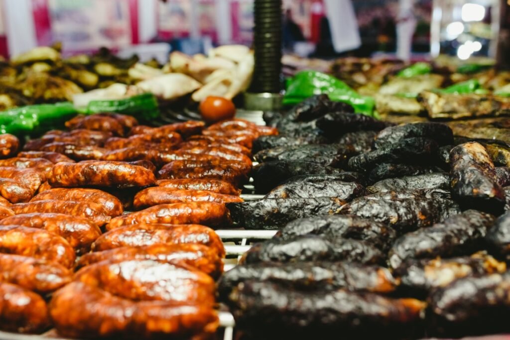 Sausages and black pudding roasted in a barbecue Rows of red and dark sausages arranged on display at a market stall, ready for sale.
